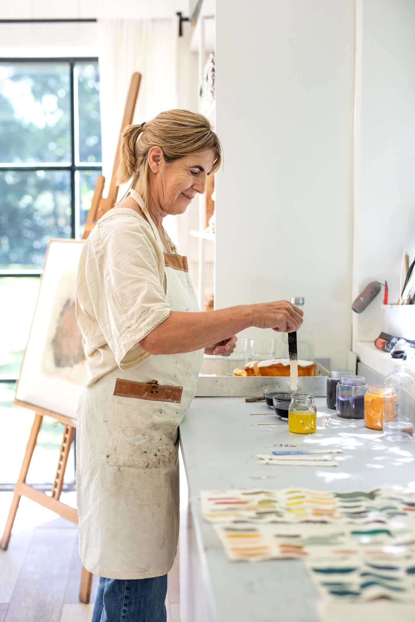 Artist painting colorful swatches on canvas