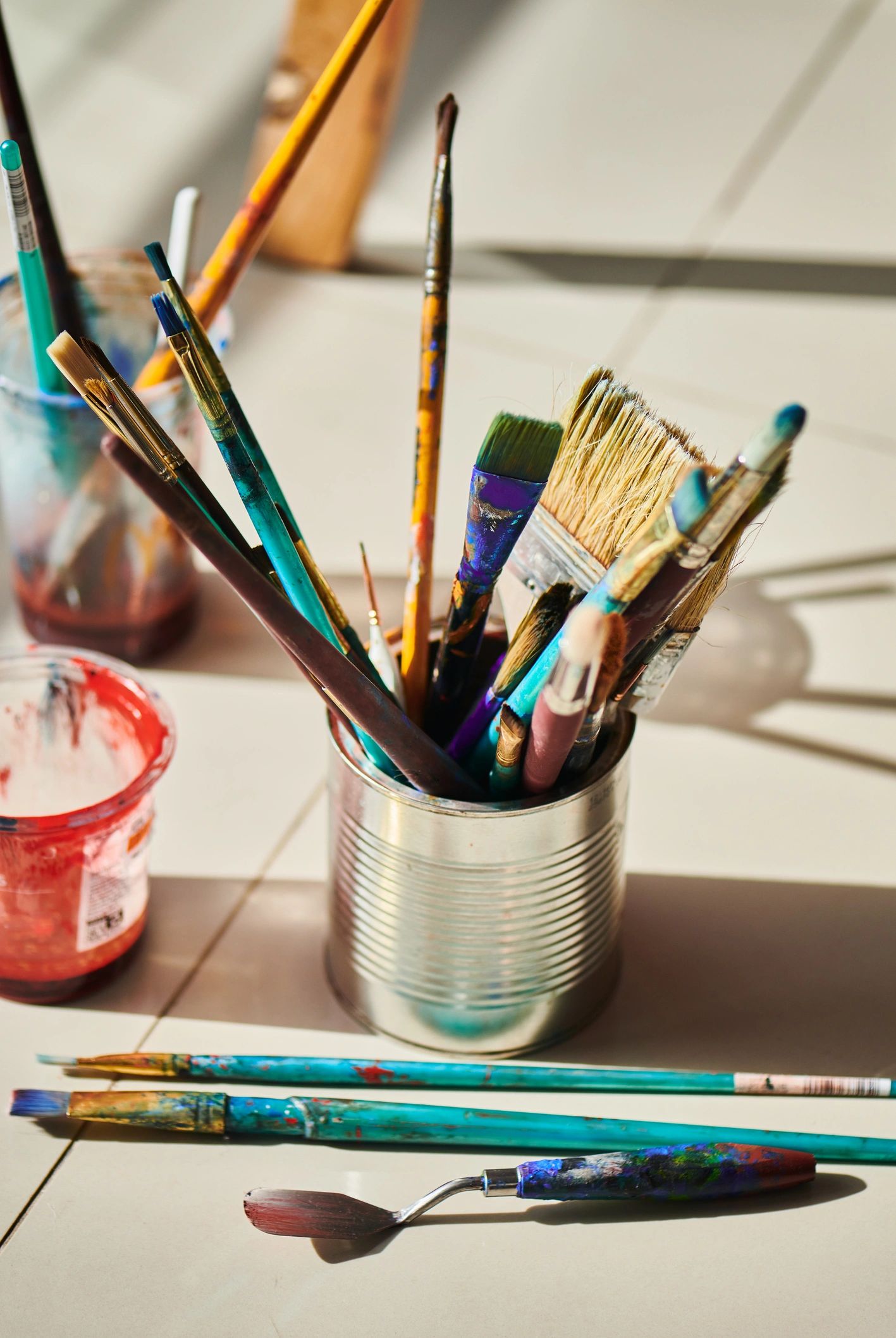 Paint brushes and palette knife in a colorful artist supply flat lay